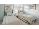 Twin beds in a bright bedroom with soft lighting, bedside table and decorative artwork at 40 Greensward Rd, Kiawah Island, SC 29455