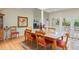 Cozy dining area with natural light, wood floors, red cushioned chairs, and views to a serene outdoor setting at 40 Greensward Rd, Kiawah Island, SC 29455