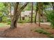 Inviting home with a lush front yard, mature trees, and a classic wood front door at 40 Greensward Rd, Kiawah Island, SC 29455