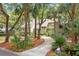 Well-maintained exterior of home highlighted by mature palm trees, landscaping, and a concrete driveway at 40 Greensward Rd, Kiawah Island, SC 29455