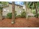 Exterior back of the house surrounded by trees, showing siding, windows, and patio at 40 Greensward Rd, Kiawah Island, SC 29455