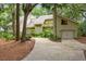 Charming light green home featuring a two-car garage, well-kept lawn, and mature trees at 40 Greensward Rd, Kiawah Island, SC 29455