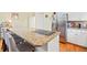 Kitchen island with cooktop and granite countertops, stainless steel refrigerator, and breakfast bar seating at 40 Greensward Rd, Kiawah Island, SC 29455