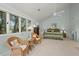 Bright main bedroom featuring vaulted ceilings, a ceiling fan and views of the surrounding greenery through the large windows at 40 Greensward Rd, Kiawah Island, SC 29455