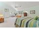 Bright main bedroom featuring vaulted ceilings, a ceiling fan and views of the surrounding greenery through the large windows at 40 Greensward Rd, Kiawah Island, SC 29455