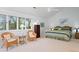 Bright main bedroom featuring vaulted ceilings, a ceiling fan and views of the surrounding greenery through the large windows at 40 Greensward Rd, Kiawah Island, SC 29455