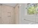 Shower featuring light tile, a built-in shelf and a view of a window with light at 40 Greensward Rd, Kiawah Island, SC 29455
