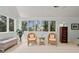 Cozy sitting area with wicker chairs, soft carpet, and an expansive window showcasing lush greenery at 40 Greensward Rd, Kiawah Island, SC 29455
