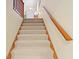 Carpeted staircase with wooden handrail leading to the upper level of the home at 40 Greensward Rd, Kiawah Island, SC 29455