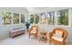 Bright sunroom featuring wicker seating, neutral carpeting, and picturesque views of the surrounding greenery at 40 Greensward Rd, Kiawah Island, SC 29455