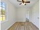 Bright, airy bedroom featuring new laminate wood flooring, a ceiling fan, and a mirrored closet ready to personalize at 400 Black Oak Rd, Bonneau, SC 29431