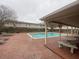 Community pool is surrounded by a brick patio with lounge chairs and tables at 415 Parkdale Dr # 6D, Charleston, SC 29414