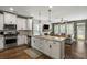 Open-concept kitchen with island seating, stainless steel appliances, and seamless flow to the living area at 423 Sanctuary Park Dr, Summerville, SC 29486