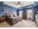Primary bedroom with tray ceiling, dark blue walls, and a cozy bed at 423 Sanctuary Park Dr, Summerville, SC 29486