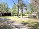 View of the backyard featuring mature trees, a storage shed, and a quaint house at 4589 Prices Bridge Ln, Walterboro, SC 29488