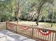 A view of the large backyard from the wooden deck decorated with a patriotic banner at 4589 Prices Bridge Ln, Walterboro, SC 29488