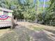View of the backyard, with its well-maintained fence, a quaint house, and mature trees at 4589 Prices Bridge Ln, Walterboro, SC 29488