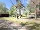 View of the backyard featuring mature trees, a storage shed, and a quaint house at 4589 Prices Bridge Ln, Walterboro, SC 29488