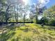 Lush backyard with mature trees, a firepit, and peaceful creek, offering serenity and natural beauty at 4589 Prices Bridge Ln, Walterboro, SC 29488
