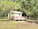 Quaint cottage with a welcoming porch, adorned with patriotic decorations and white chairs at 4589 Prices Bridge Ln, Walterboro, SC 29488