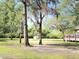 View of the front yard with mature trees and a glimpse of the home's deck at 4589 Prices Bridge Ln, Walterboro, SC 29488