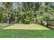 Spacious, fenced-in backyard with lush green grass and mature trees surrounding the property at 493 Trotters Ln, Moncks Corner, SC 29461