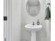 Charming powder room featuring a pedestal sink, round mirror, and decorative accents at 493 Trotters Ln, Moncks Corner, SC 29461
