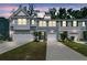 Charming townhome with gray siding, white garage doors, and well-maintained landscaping at sunset at 493 Trotters Ln, Moncks Corner, SC 29461
