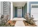 Charming front porch with teal siding, white columns, manicured bushes, and a welcome sign at 493 Trotters Ln, Moncks Corner, SC 29461