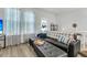 Open living space featuring wood floors, dark sofa with decorative pillows, and sun-filled windows at 493 Trotters Ln, Moncks Corner, SC 29461