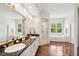 Well-lit bathroom with double sinks, granite counters, walk-in shower, and a soaking tub in a bright, airy space at 510 Traders Aly, Mount Pleasant, SC 29464