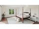 Bright bedroom featuring a four-poster bed, hardwood floors, shutters, and a neutral-toned rug at 510 Traders Aly, Mount Pleasant, SC 29464