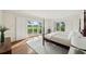 Bright bedroom with four-poster bed, hardwood floors, shutters, and balcony access offering scenic outdoor views at 510 Traders Aly, Mount Pleasant, SC 29464