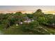 Aerial view of a brick two-story home situated among dense trees and lush landscaping at sunset at 510 Traders Aly, Mount Pleasant, SC 29464