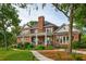 Brick two-story home with a columned porch and manicured landscaping is surrounded by large trees and a green lawn at 510 Traders Aly, Mount Pleasant, SC 29464