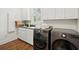 Bright laundry room featuring modern washer/dryer, cabinets and sink, with hardwood floors at 510 Traders Aly, Mount Pleasant, SC 29464