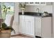 A wet bar area features white cabinets, a stainless beverage cooler, granite countertops, and a window view at 510 Traders Aly, Mount Pleasant, SC 29464