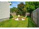 A backyard firepit surrounded by Adirondack chairs and lush green grass at 518 Cecilia Cove Dr, Charleston, SC 29412