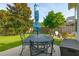 Inviting patio area with a metal table set, blue umbrella, and view of the fenced backyard at 518 Cecilia Cove Dr, Charleston, SC 29412