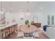 Bright dining room featuring a wooden table, modern chandelier, and open layout to the kitchen and living areas at 5710 Barbary Coast Rd, Hollywood, SC 29449