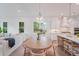 Bright dining area with wooden table, chairs and chandelier opens up into the kitchen and sunlit living room at 5710 Barbary Coast Rd, Hollywood, SC 29449
