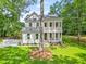Charming two-story home featuring a double porch, manicured lawn, and a classic white facade at 5710 Barbary Coast Rd, Hollywood, SC 29449