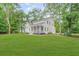 Charming exterior of a white two-story home with a well-manicured lawn and mature trees at 5710 Barbary Coast Rd, Hollywood, SC 29449