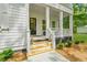 Inviting front porch with white columns and stairs, complemented by planters and manicured landscaping at 5710 Barbary Coast Rd, Hollywood, SC 29449
