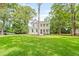 Charming two-story home featuring a welcoming front porch, surrounded by lush green grass and mature trees at 5710 Barbary Coast Rd, Hollywood, SC 29449