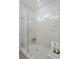 Walk-in shower featuring marbled tile, glass enclosure, and small wooden stool at 5710 Barbary Coast Rd, Hollywood, SC 29449