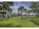 Green backyard with tall palm trees, offering privacy and serene views from the home's elevated porch at 633 Stono Edge Dr, Charleston, SC 29412