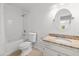 This bathroom has a bath tub and a granite-topped vanity with a round mirror at 633 Stono Edge Dr, Charleston, SC 29412