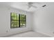 A bright bedroom featuring a large window overlooking outside greenery and soft carpet flooring at 633 Stono Edge Dr, Charleston, SC 29412