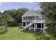 Beautiful elevated home with a screened-in porch and well-manicured lawn at 633 Stono Edge Dr, Charleston, SC 29412